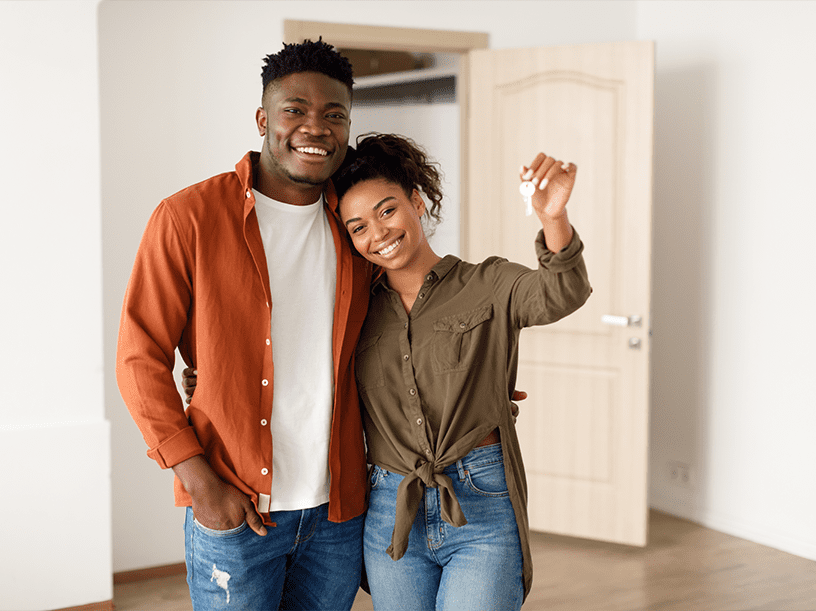 Man and woman couple homeowners holding keys to their new home inside the house. Structur Residential Construction Consulting